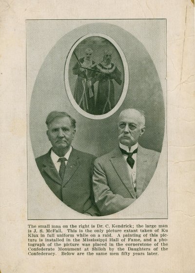 Foto van twee mannen in burgerkleding onder een afbeelding van twee Ku Klux Klansleden door Unknown